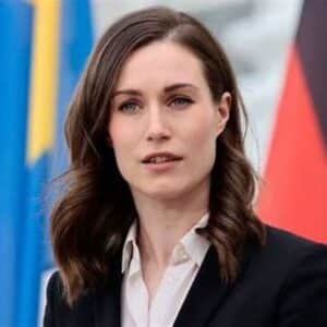 Sanna kuvattuna puhetta pitämässä lavalla, Ruotsin lippu takana lepäämässä